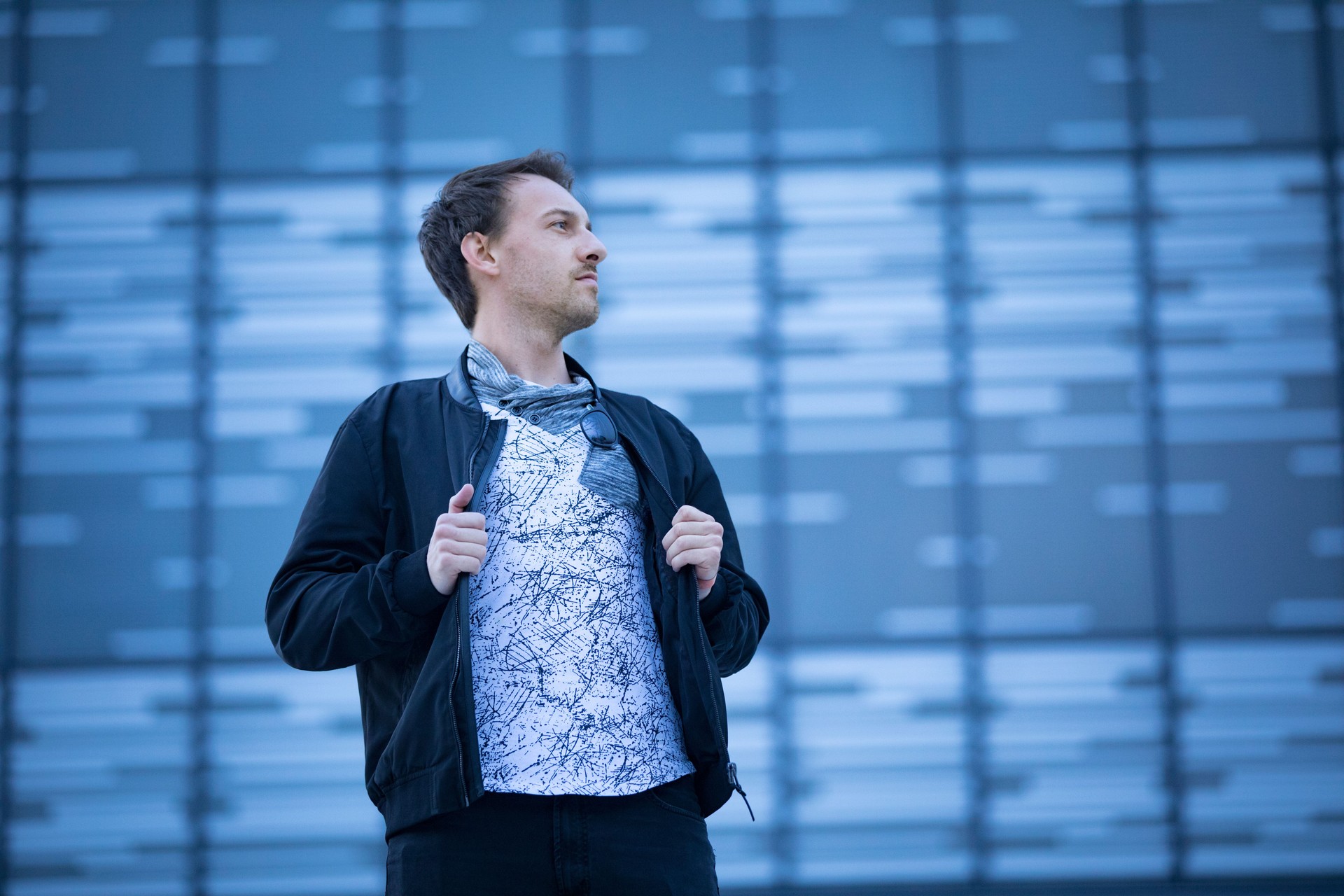 Portrait of Young Adult Man Putting on Jacket on City Street